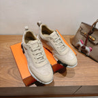 Cream suede lace-up sneakers on orange box with padded tongue and chunky sole