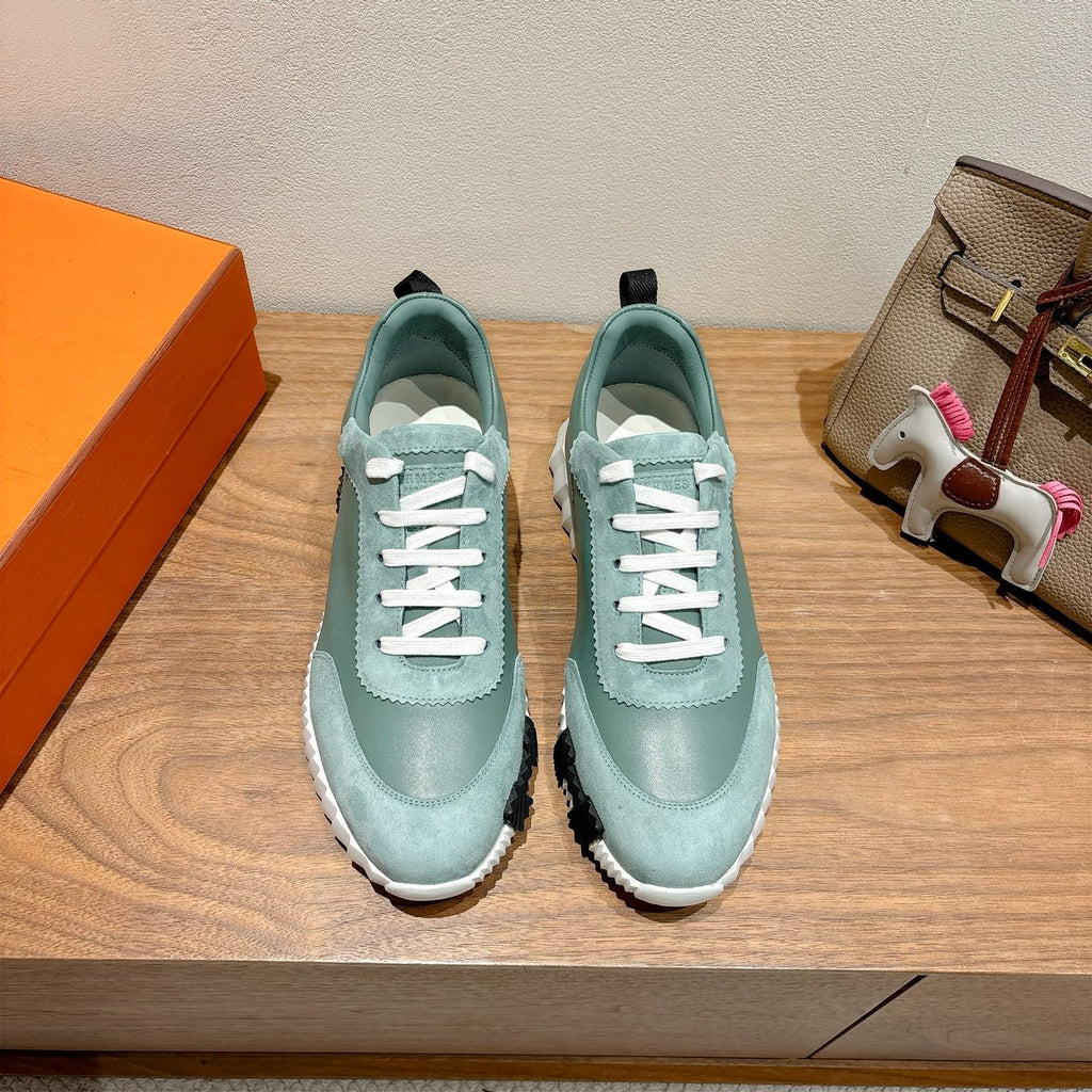 Hermes mint unisex sneakers with white laces, side logo, and textured black sole.