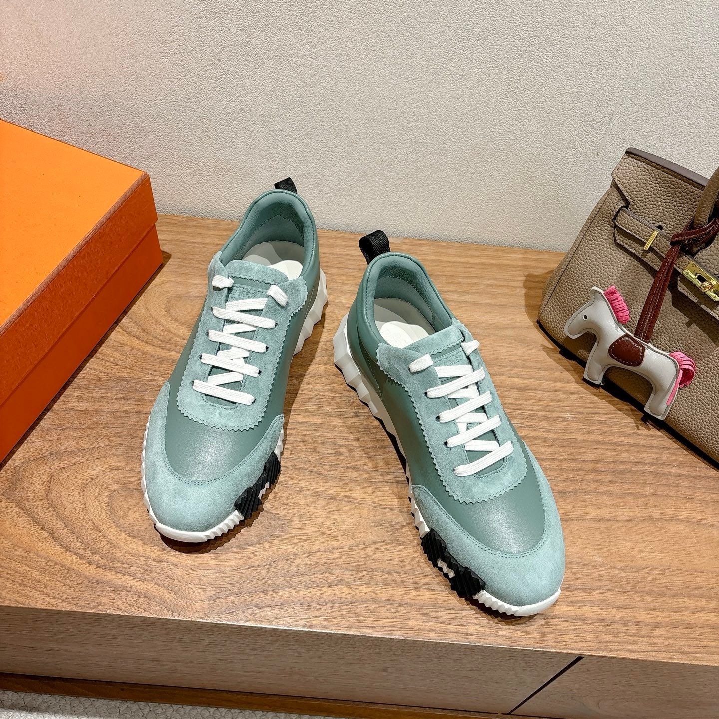 Hermes mint unisex lace-up sneakers with white laces and textured black sole.