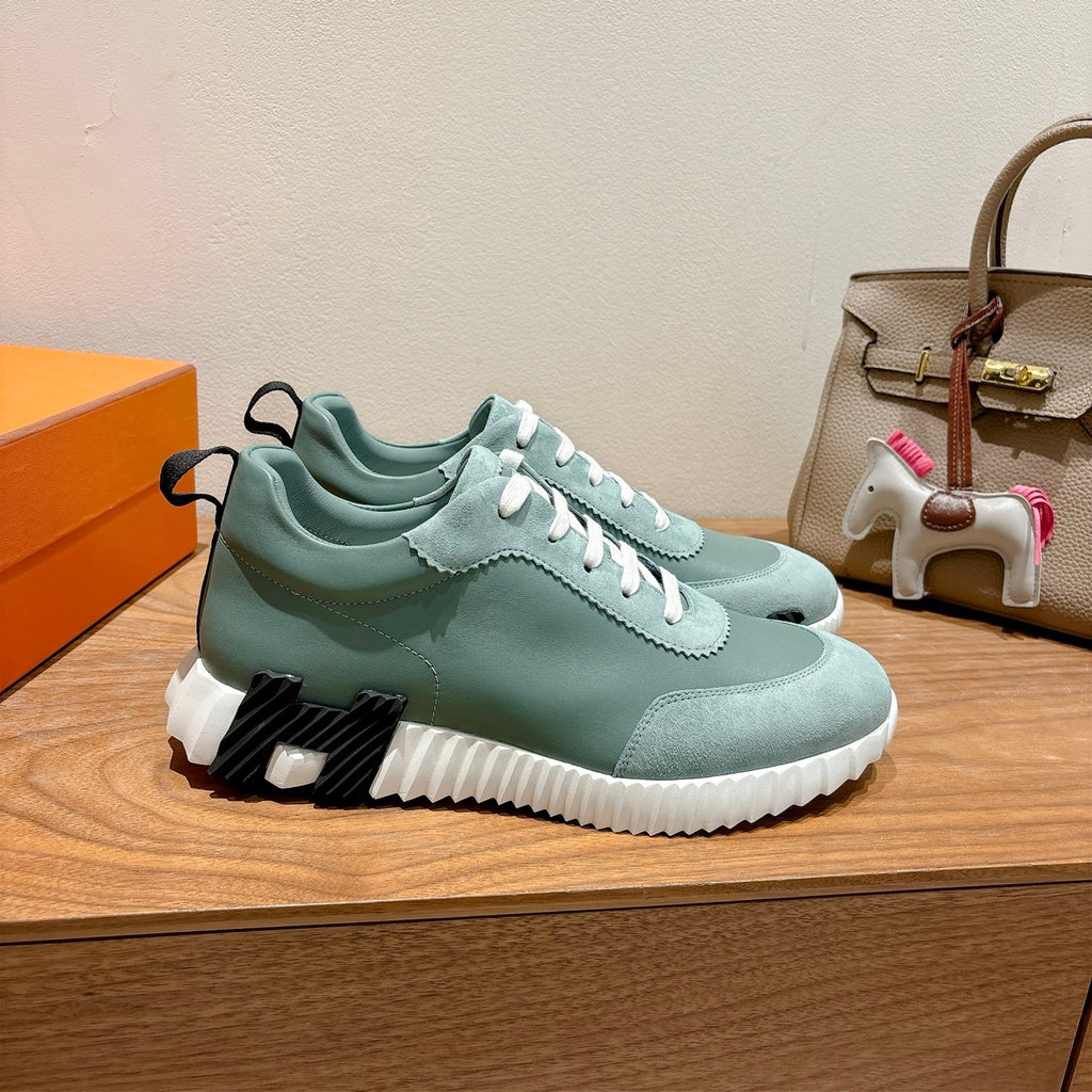 Hermes mint unisex sneaker side view with white laces, scalloped trim, chunky sole.