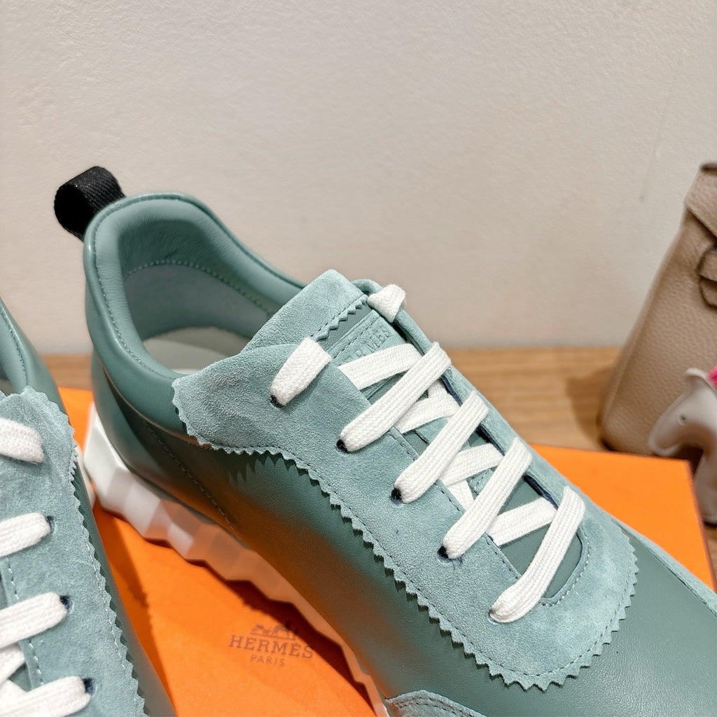 Hermes mint unisex sneaker close-up with white laces, stitched panel, black outsole.