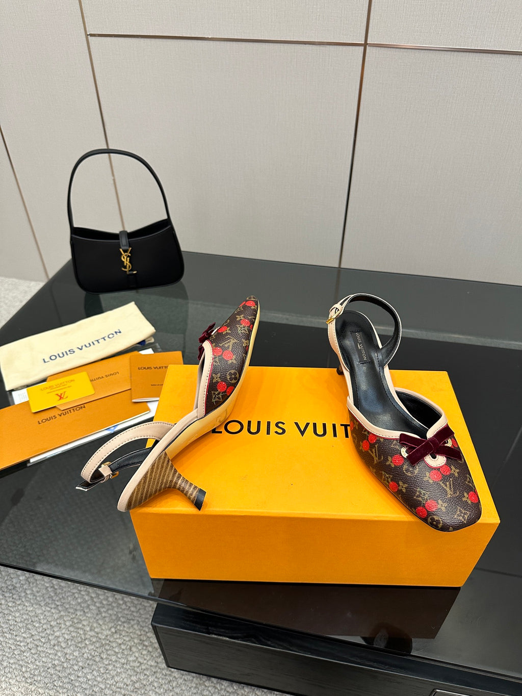 Women's Louis Vuitton monogram slingback heels with red bow and beige heel tips, close view