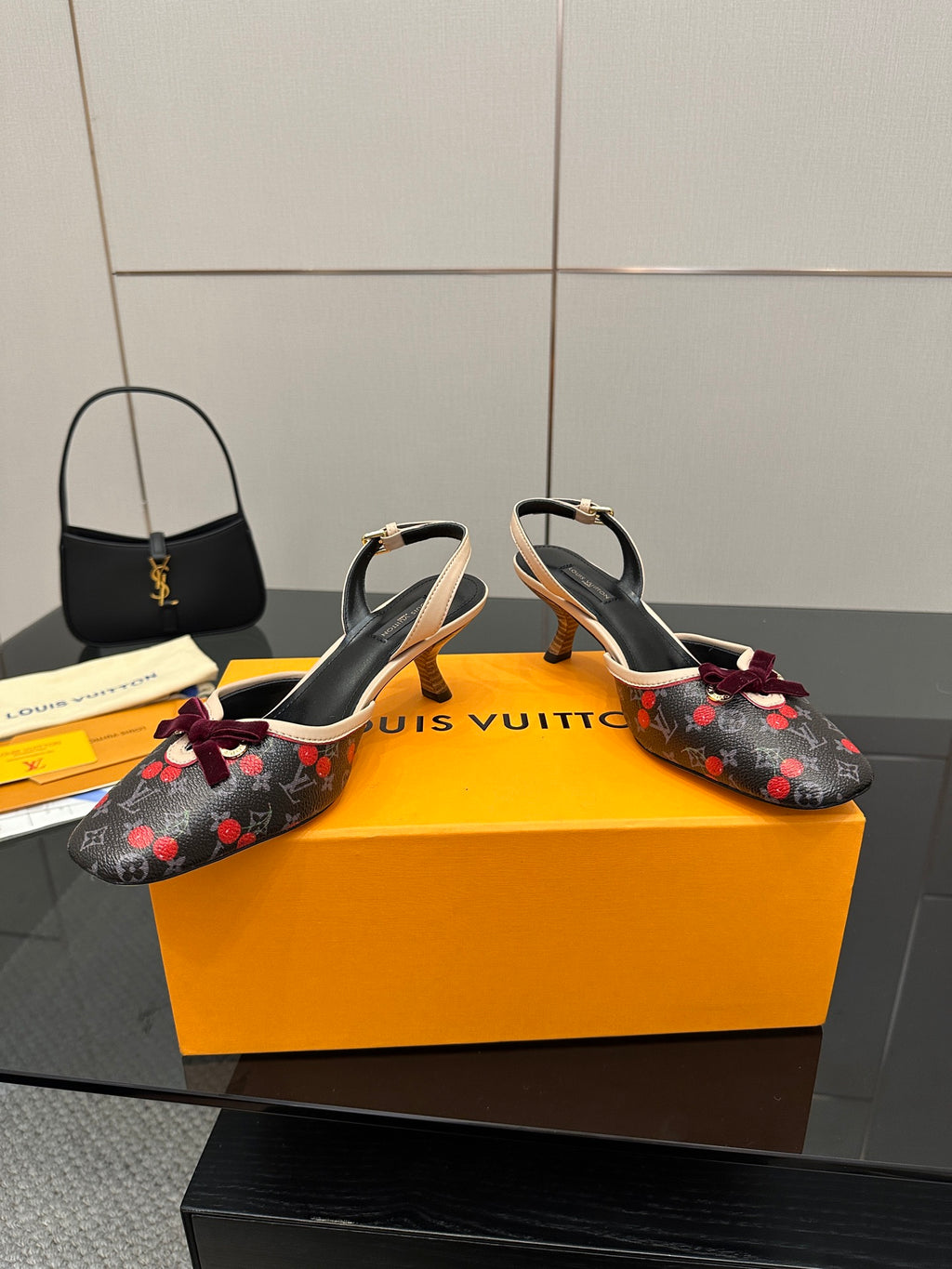Pair of women’s slingback flats with cherry print, burgundy bows, black straps, kitten heels