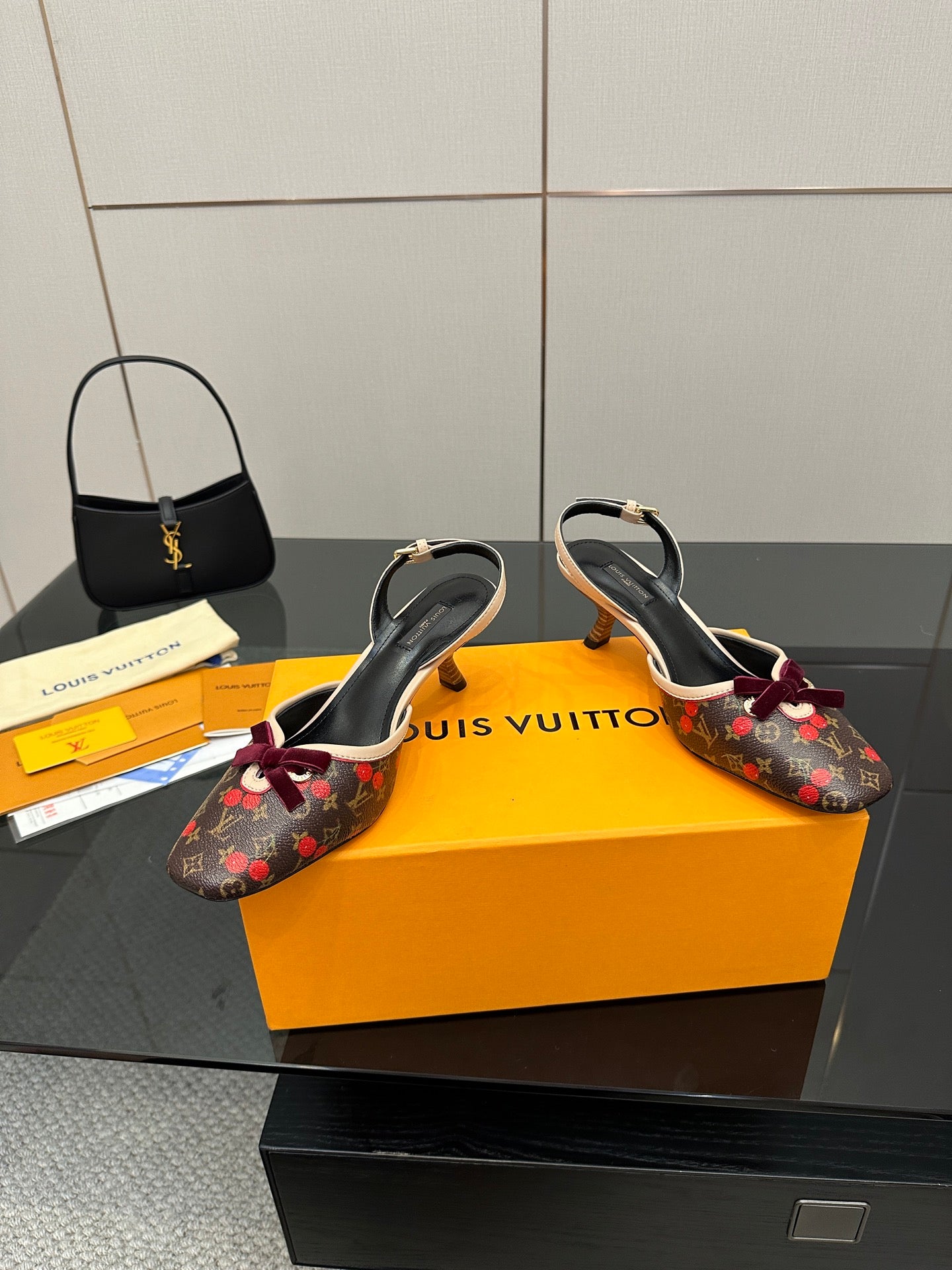 Women's Louis Vuitton monogram slingback heels with red bow, two shoes side-by-side