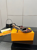 Women's Louis Vuitton monogram slingback heels with red bow and strap, angled view