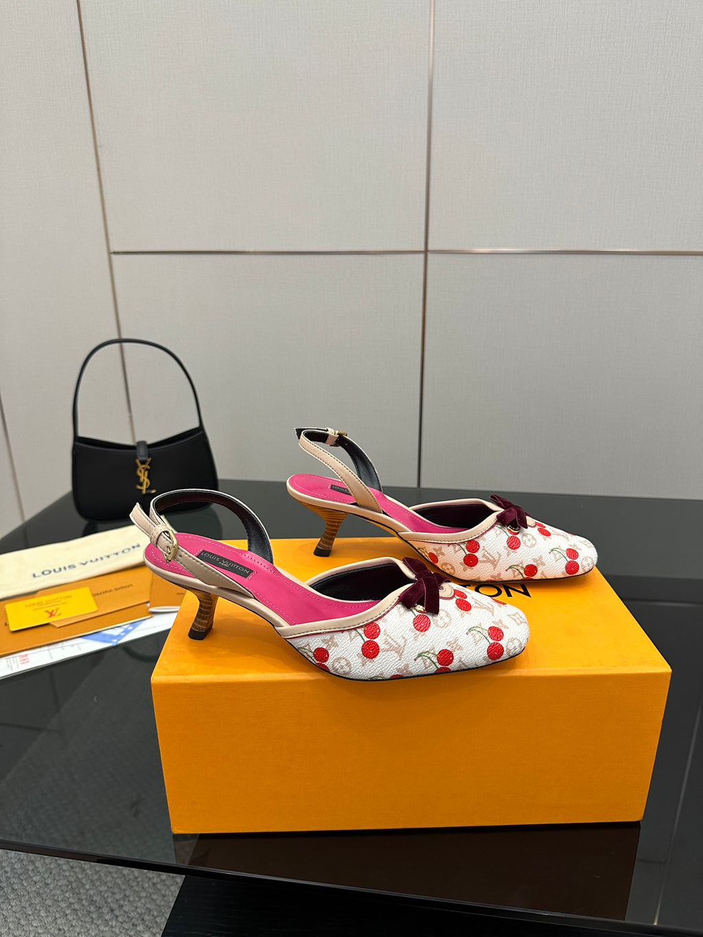 Heeled slingback shoes in white with red cherries, fuchsia insoles, and bow detail.