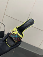 Louis Vuitton slide sandal in multicolor monogram with neon green trim, held in glove