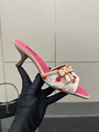 Pink and white cherry print heeled mule held in black glove