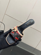 Louis Vuitton ladies slide mules held in hand, black with red cherry print, beige lining