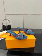Louis Vuitton women's blue monogram heeled mules, side view with red accents