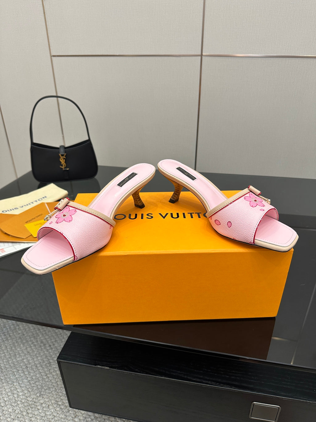 Pink leather slide sandals with floral strap, buckle detail, and block heel