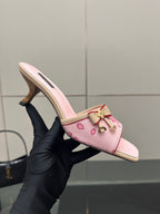 Pink slide mule sandal with floral appliqué strap and wooden-look block heel