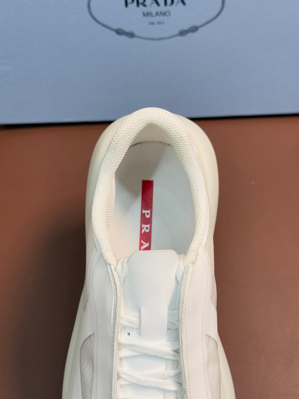 Prada unisex sneaker interior view, light cream leather upper and white laces