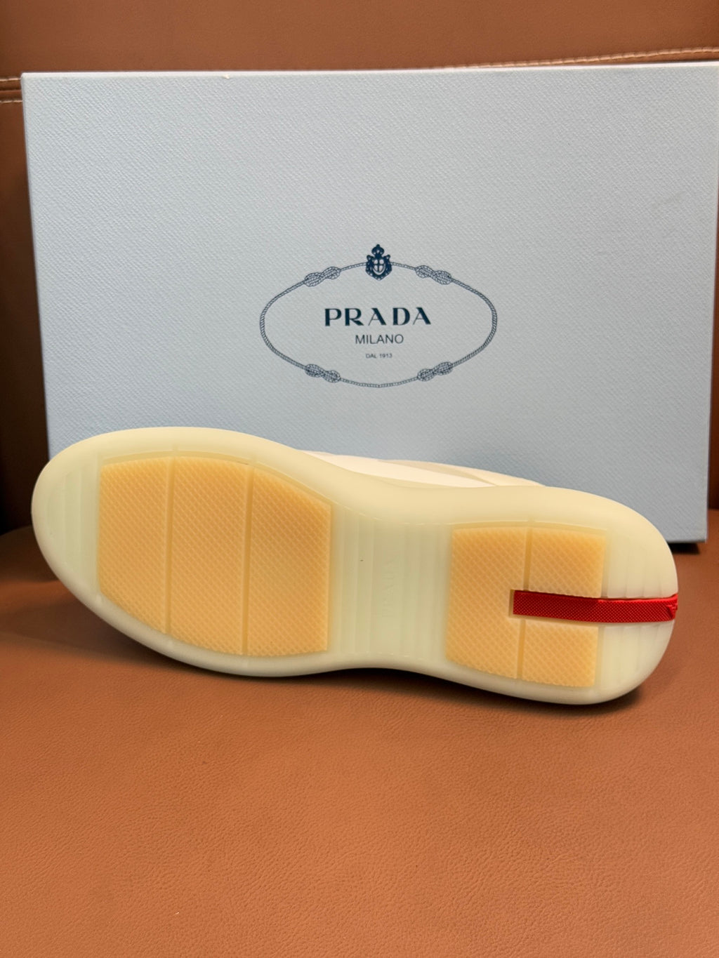 Prada unisex sneaker outsole, light cream rubber sole with Prada branding on heel
