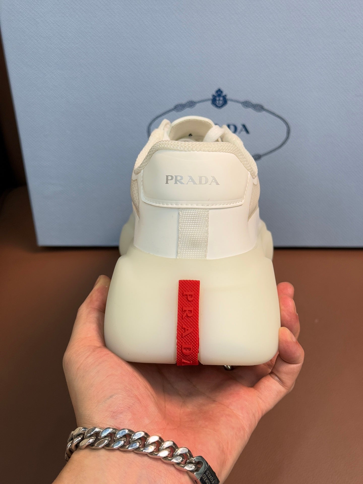 Prada unisex sneaker heel, light cream leather with red logo tab on back