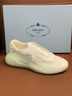 Prada unisex low-top sneaker, light cream leather, side profile with lace-up and swoosh-like patch