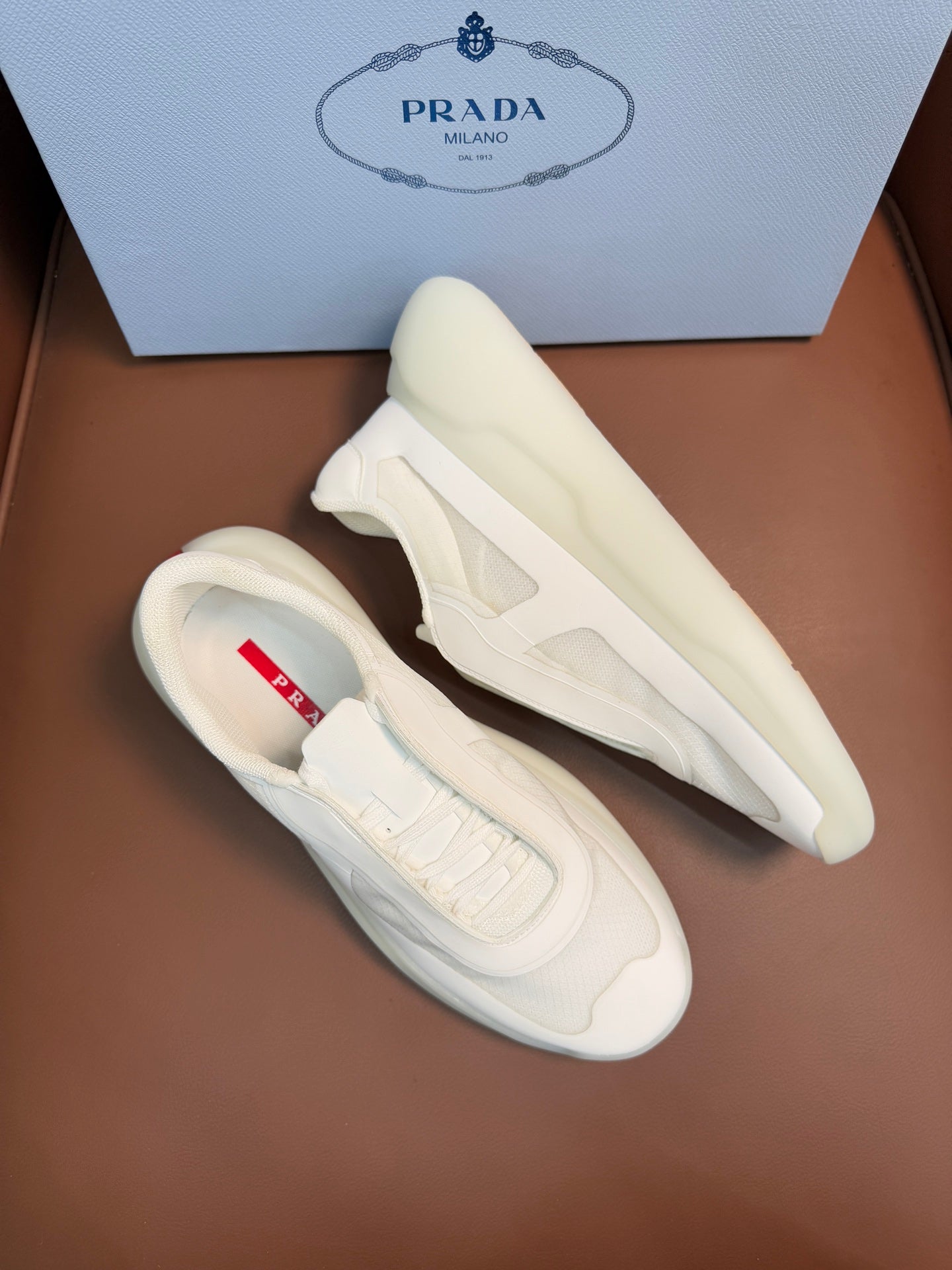 Prada unisex low-top sneakers, light cream leather, side view with lace-up detail