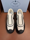Bi-color low-top sneakers, cream and dark gray with black trim and chunky sole