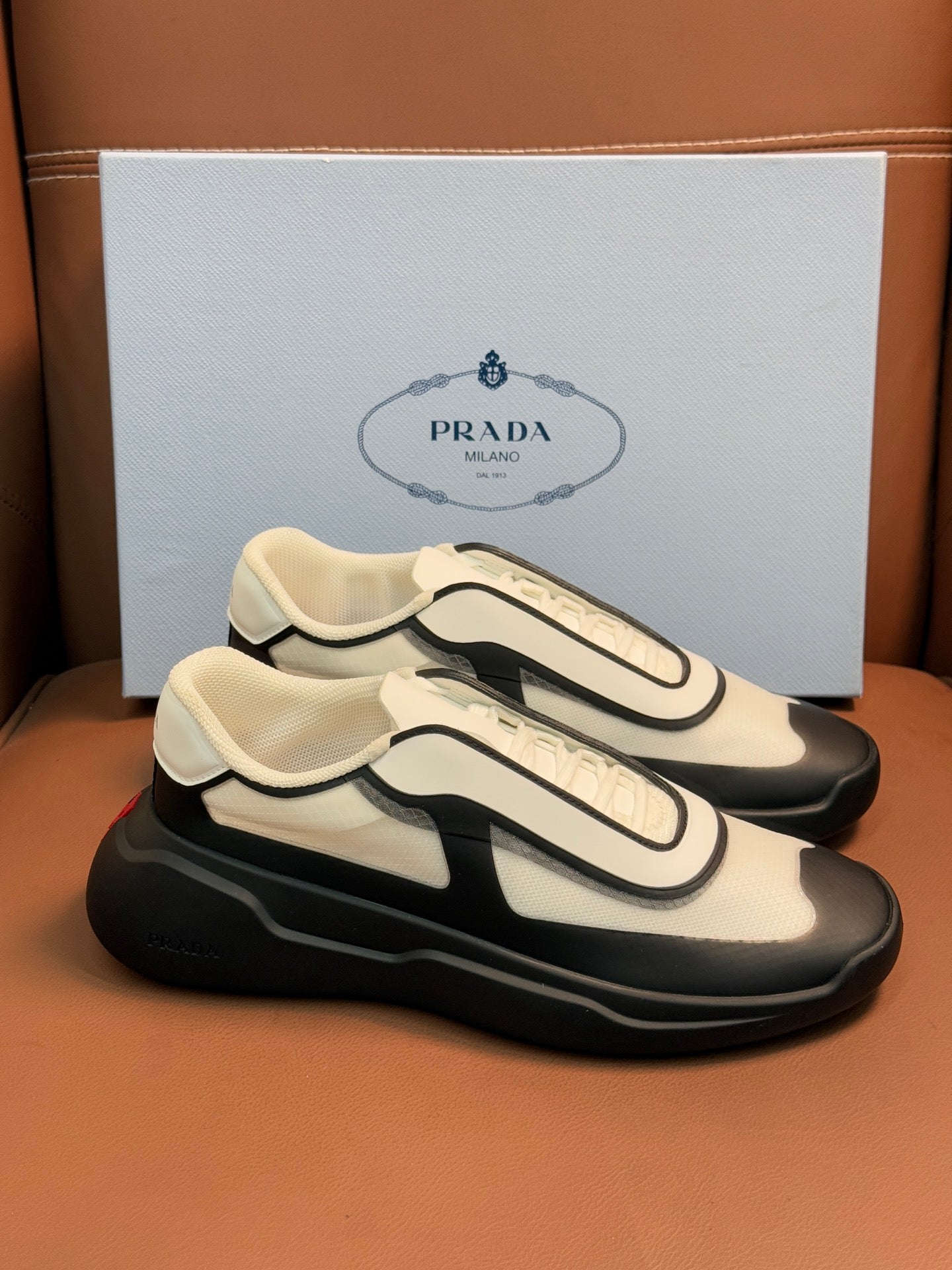 Bi-color low-top sneakers, cream upper with black paneling and chunky sole