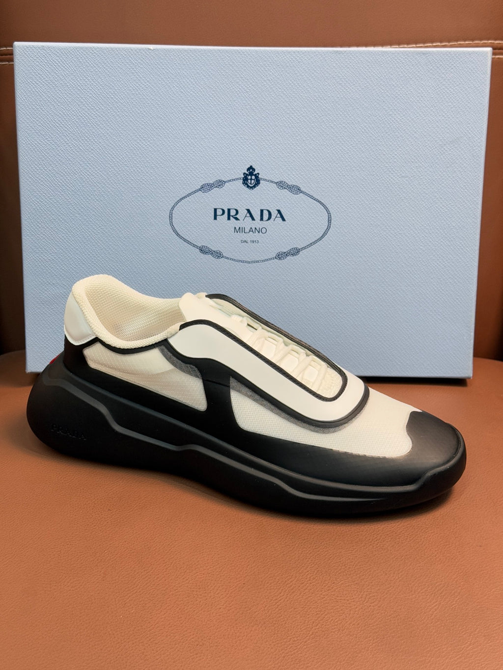 Cream and black sneakers with strap-like detailing and cushioned sole