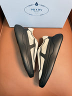 Pair of bi-color sneakers, black and cream uppers with thick rubber sole