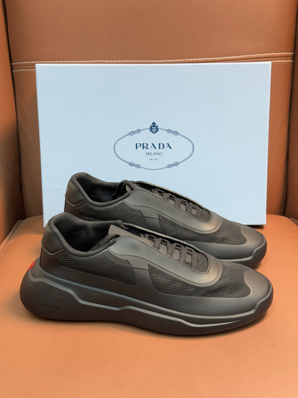 Prada unisex sneakers, dark gray, front lace-up with logo patch and cushioned sole.