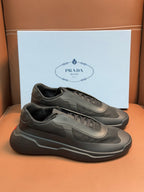 Prada unisex sneakers, dark gray, front lace-up with logo patch and cushioned sole.
