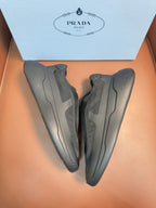 Prada unisex sneakers, dark gray, heel view with molded side stripes.