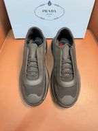 Prada unisex low-top sneakers in dark gray, mesh panels and lace-up front.