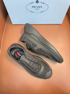 Prada unisex sneakers, dark gray, side profile with lace-up and rubber sole.