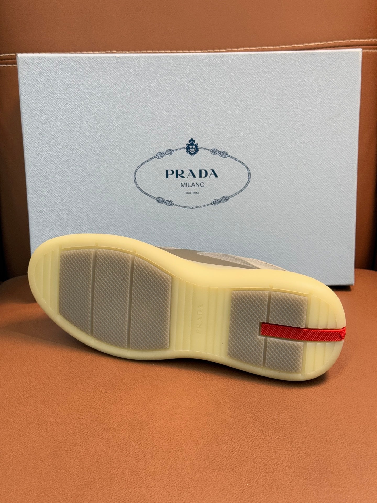 Prada unisex sneakers outsole, textured light sole with red logo heel trim