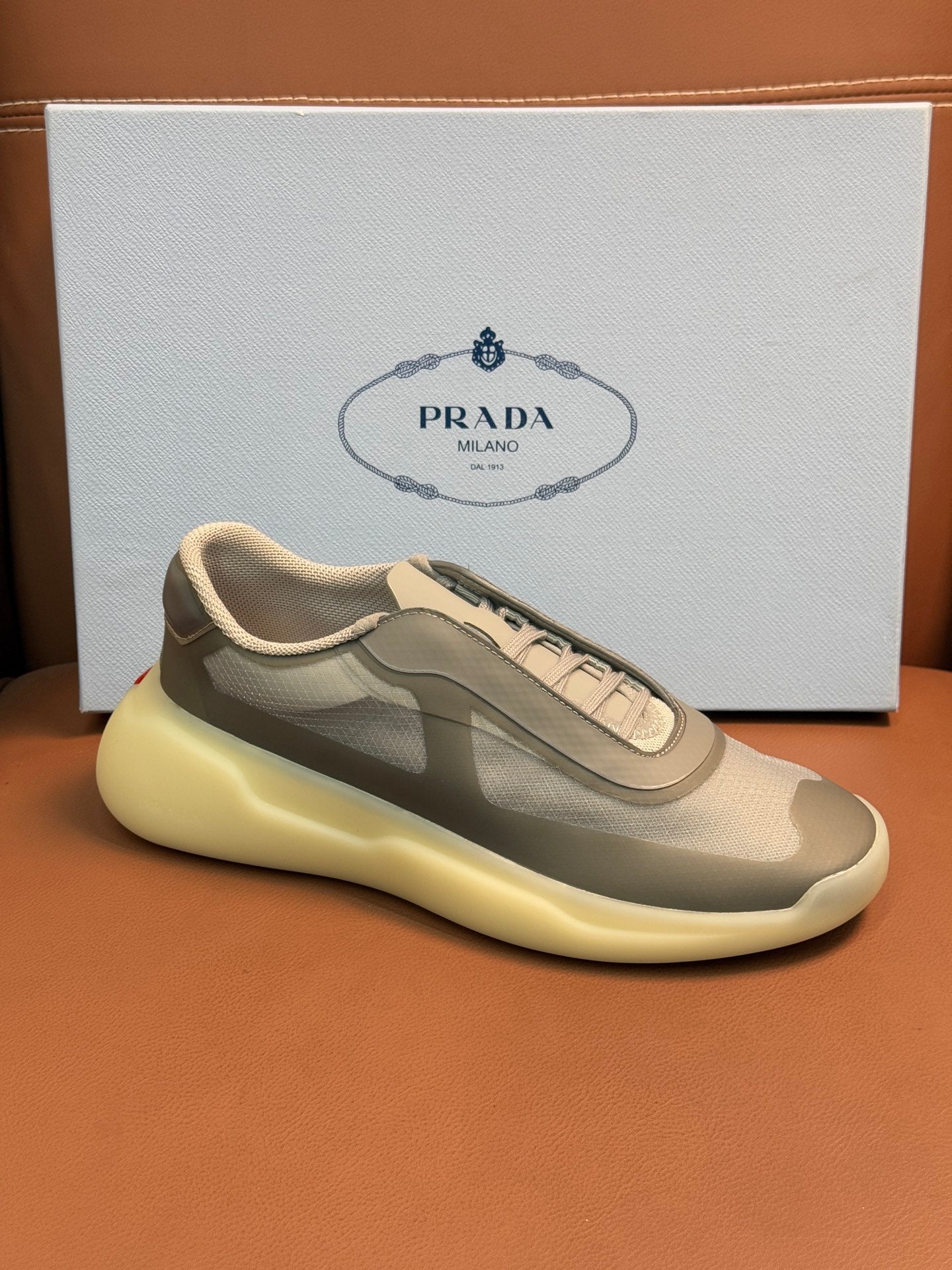 Prada unisex sneakers, front view, cream-beige upper, gray overlays, laces, yellow sole