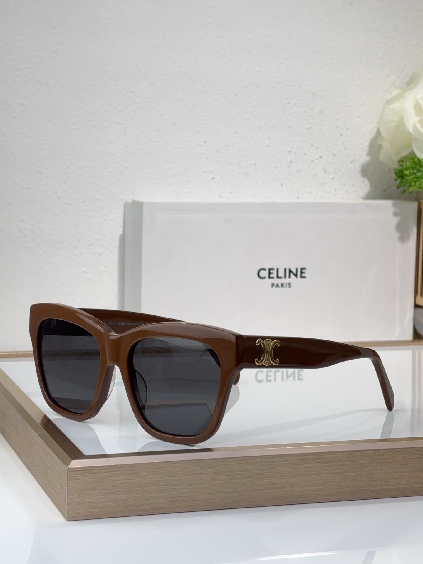 Brown sunglasses with square cat-eye frames and dark tinted lenses