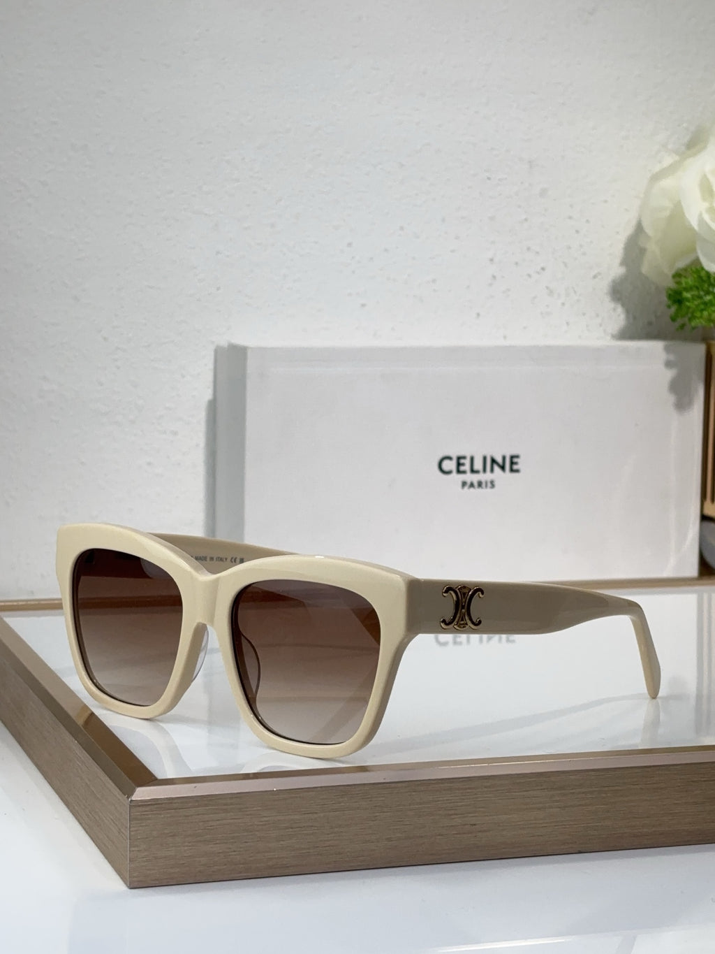 Cream sunglasses with square cat-eye frames and dark tinted lenses