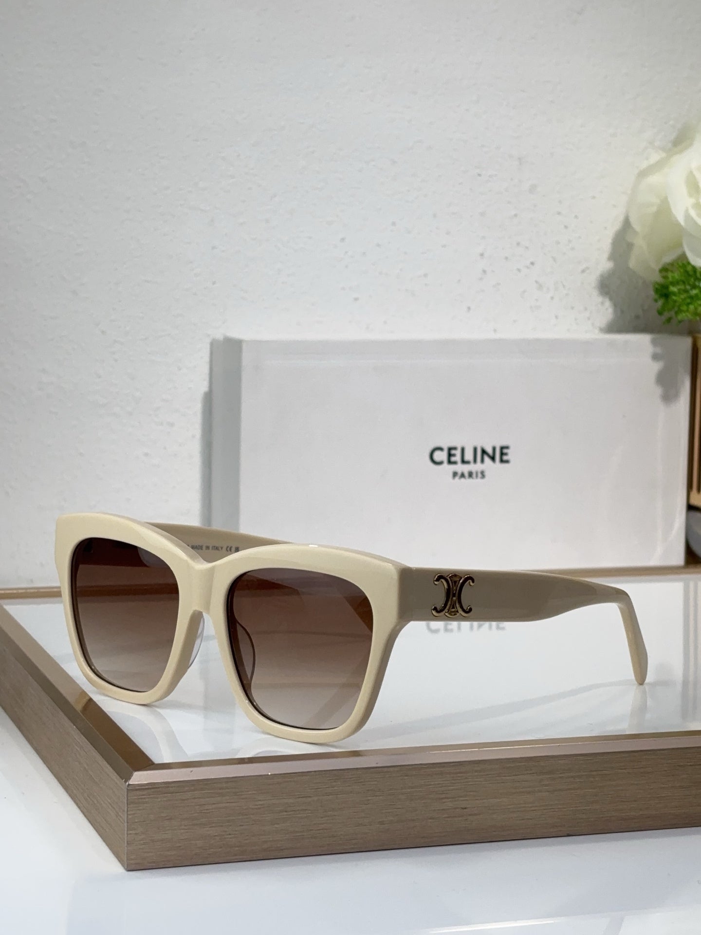 Cream sunglasses with square cat-eye frames and dark tinted lenses