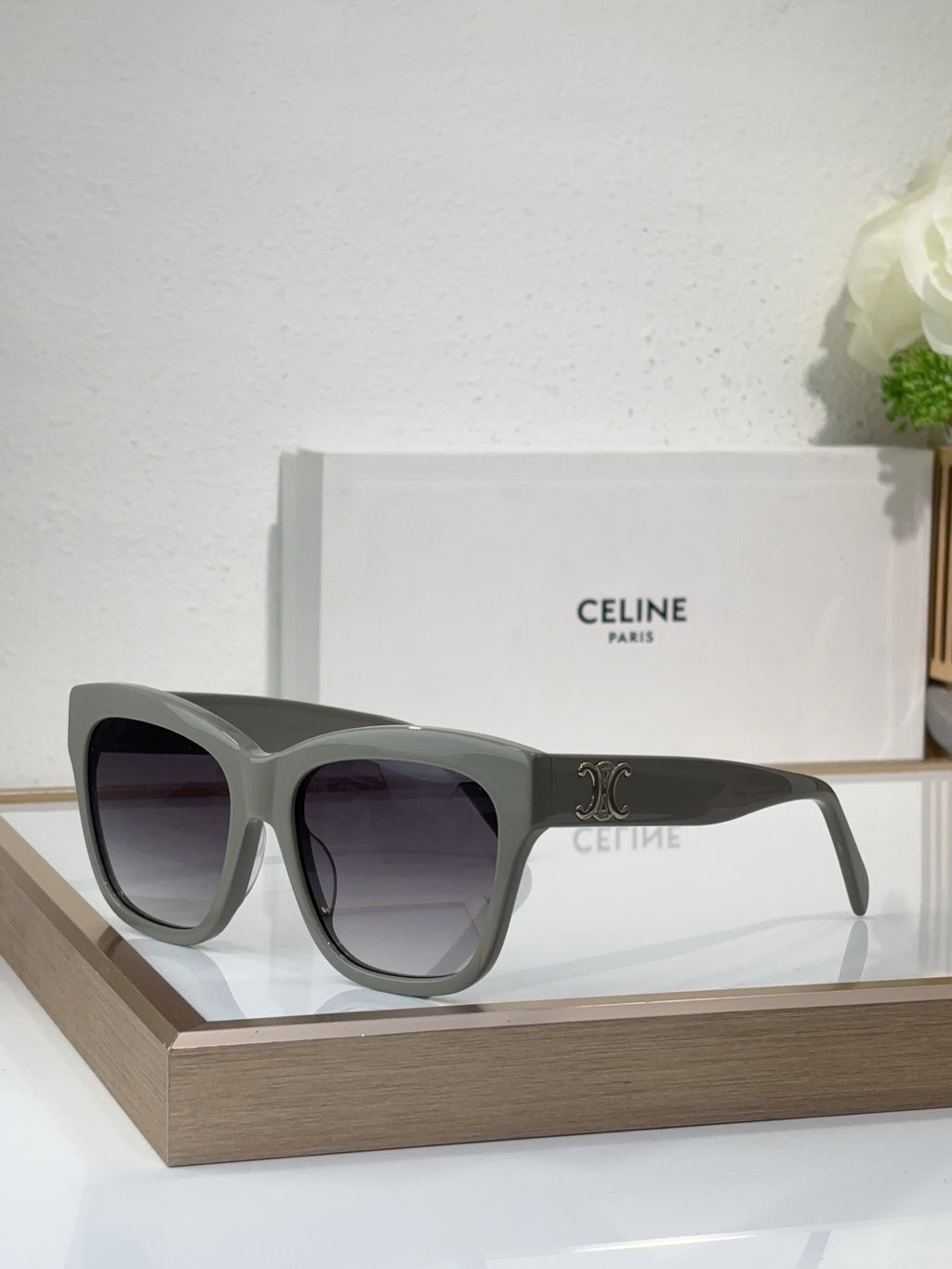 Gray sunglasses with square cat-eye frames and purple-tinted lenses