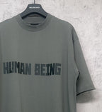 Balenciaga crewneck T-shirt side angle, dark gray-green with “HUMAN BEING” print