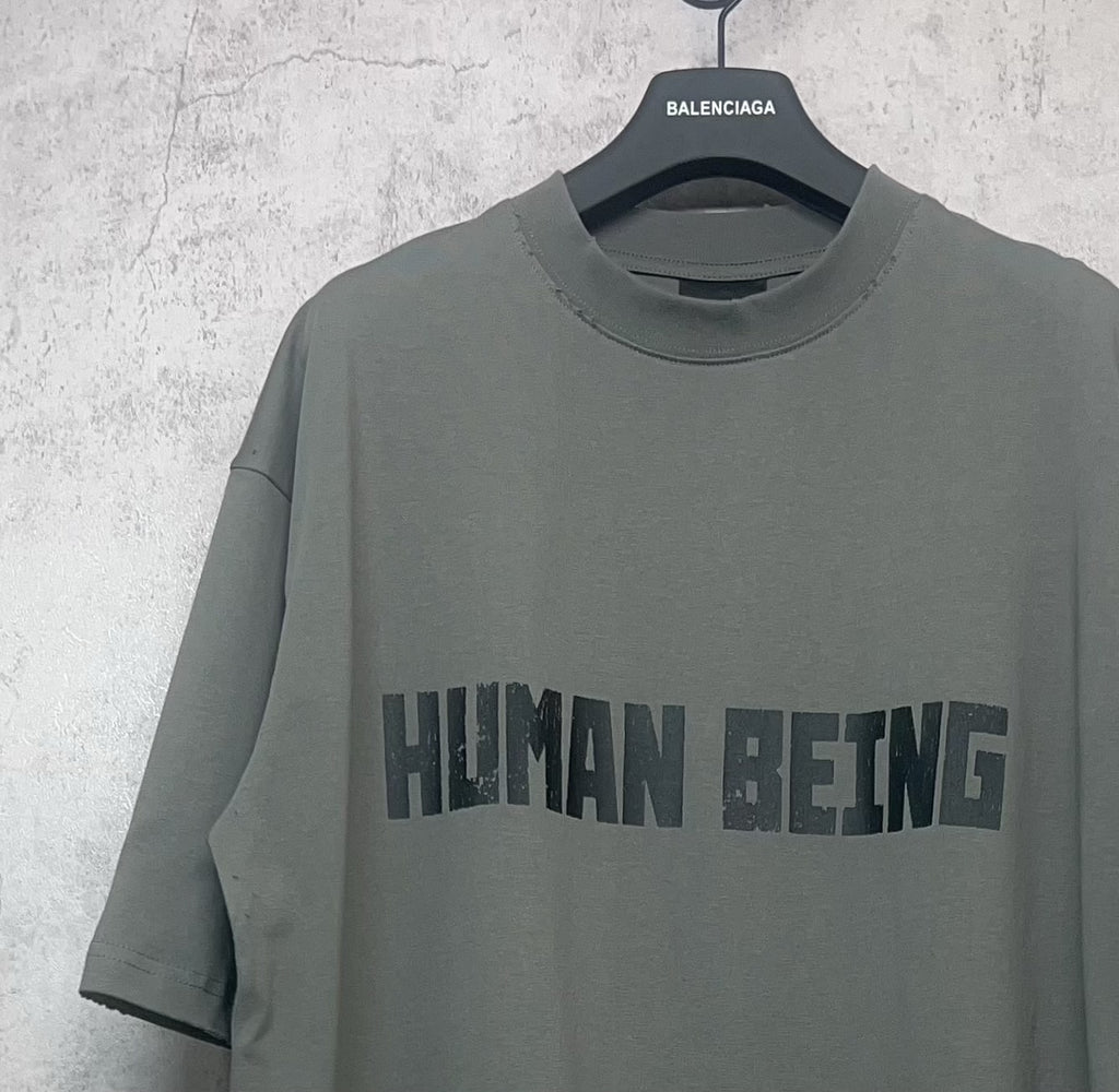 Balenciaga crewneck T-shirt front view, dark gray-green, “HUMAN BEING” print