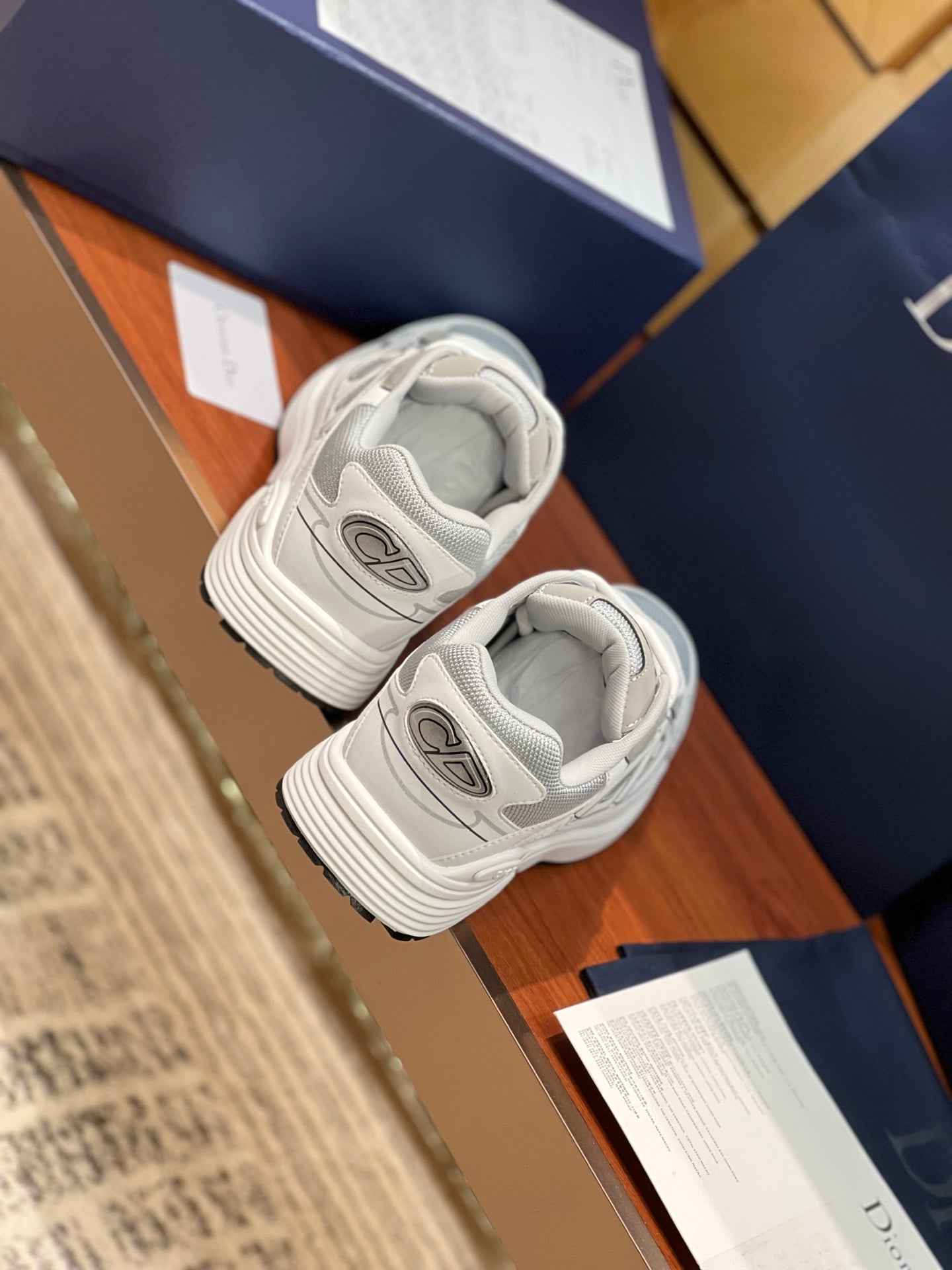 Two light gray sneakers resting with lace-up fronts and ribbed sole edges