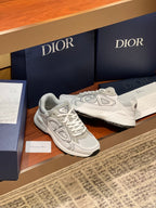 Pair of light gray lace-up sneakers with layered panels and logo branding