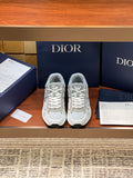 Pair of light gray sneakers with lace-up front and embroidered logo patches
