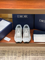 Pair of light gray sneakers with lace-up front and embroidered logo patches