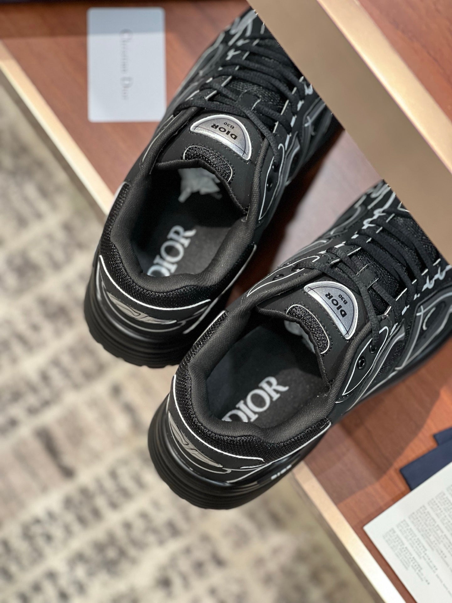 Dior ladies sneakers close-up: dark gray upper with laces and white signature print