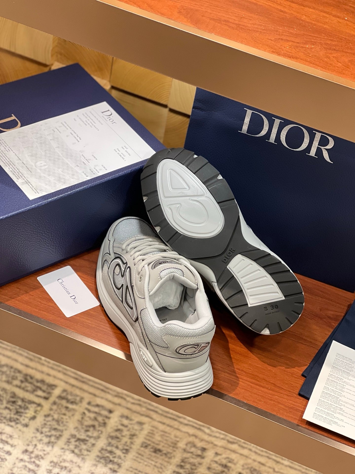Dior ladies sneakers with outsole view, light gray uppers and treaded rubber soles