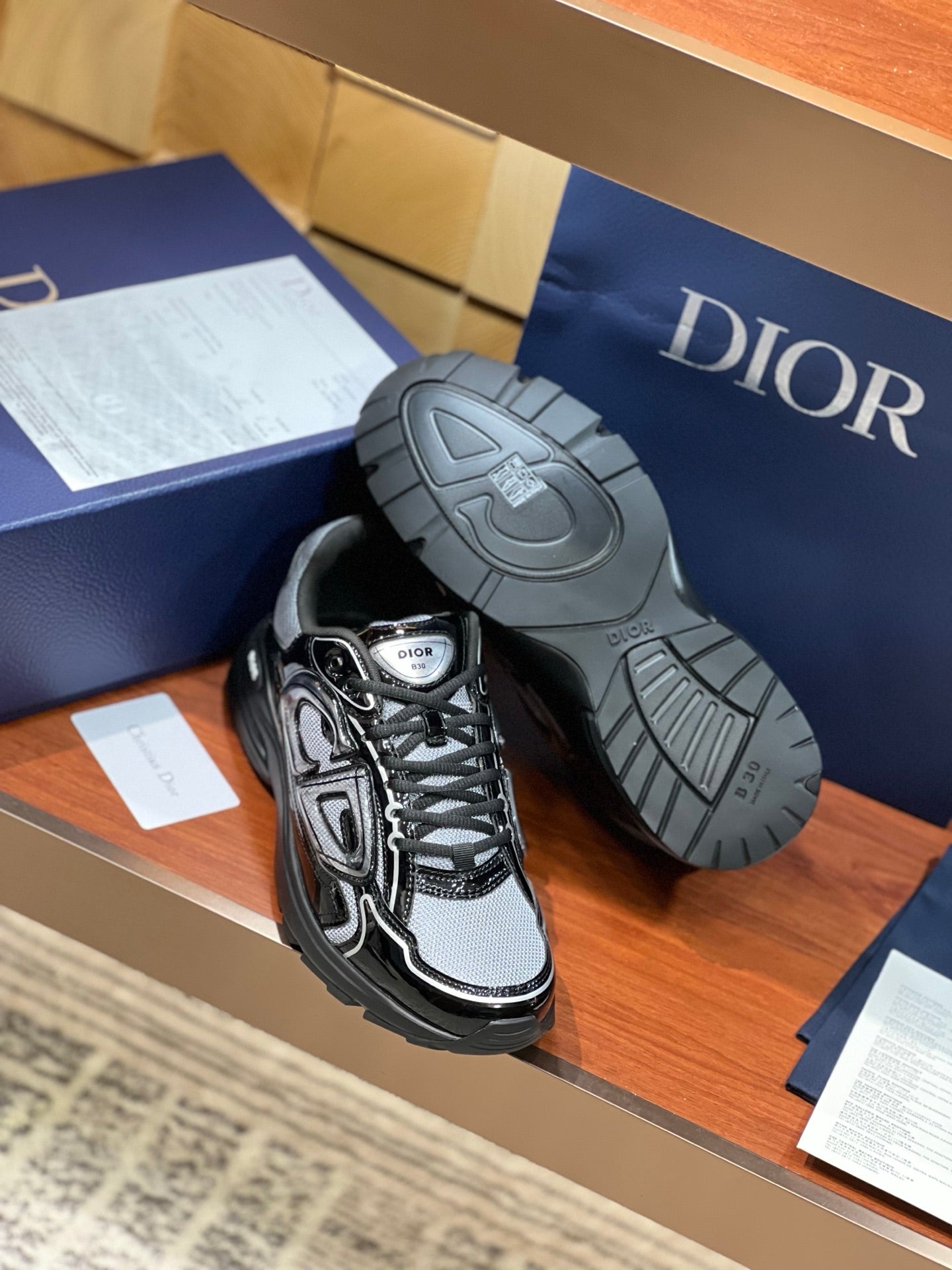 Black and gray lace-up sneakers with view of rubber outsole tread and heel logo