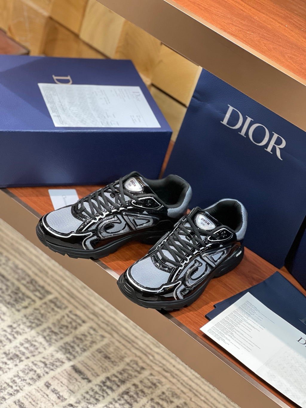 Black and gray lace-up sneakers, side view, with patterned panels and chunky soles