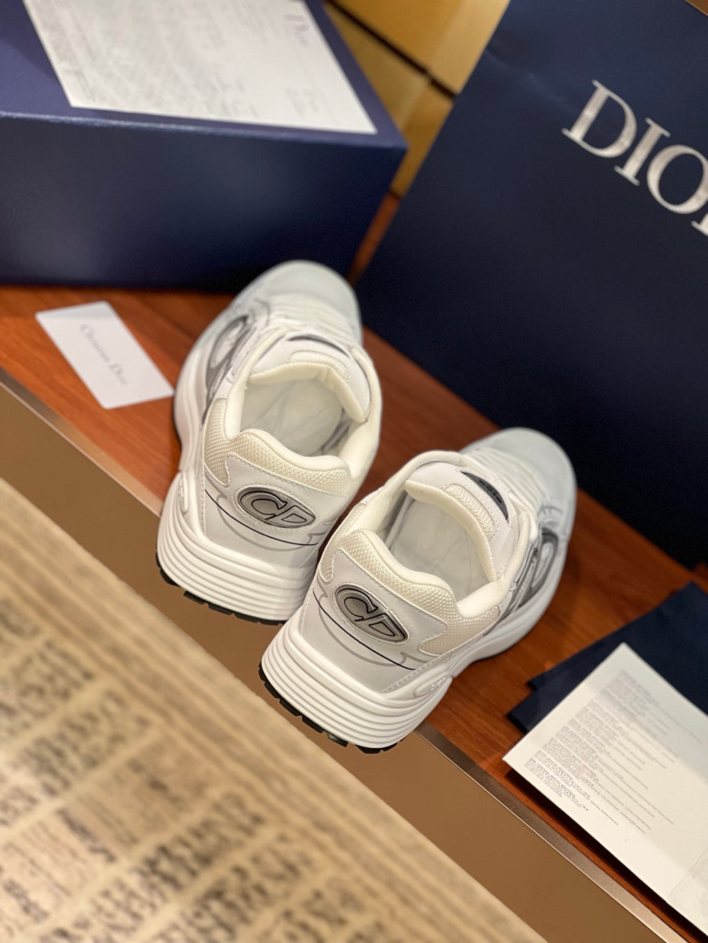 White Dior sneakers with gray accents, rear view of lace-up heel and stacked sole