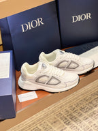White Dior lace-up sneakers with gray side emblems and chunky sole, two-shoe angle