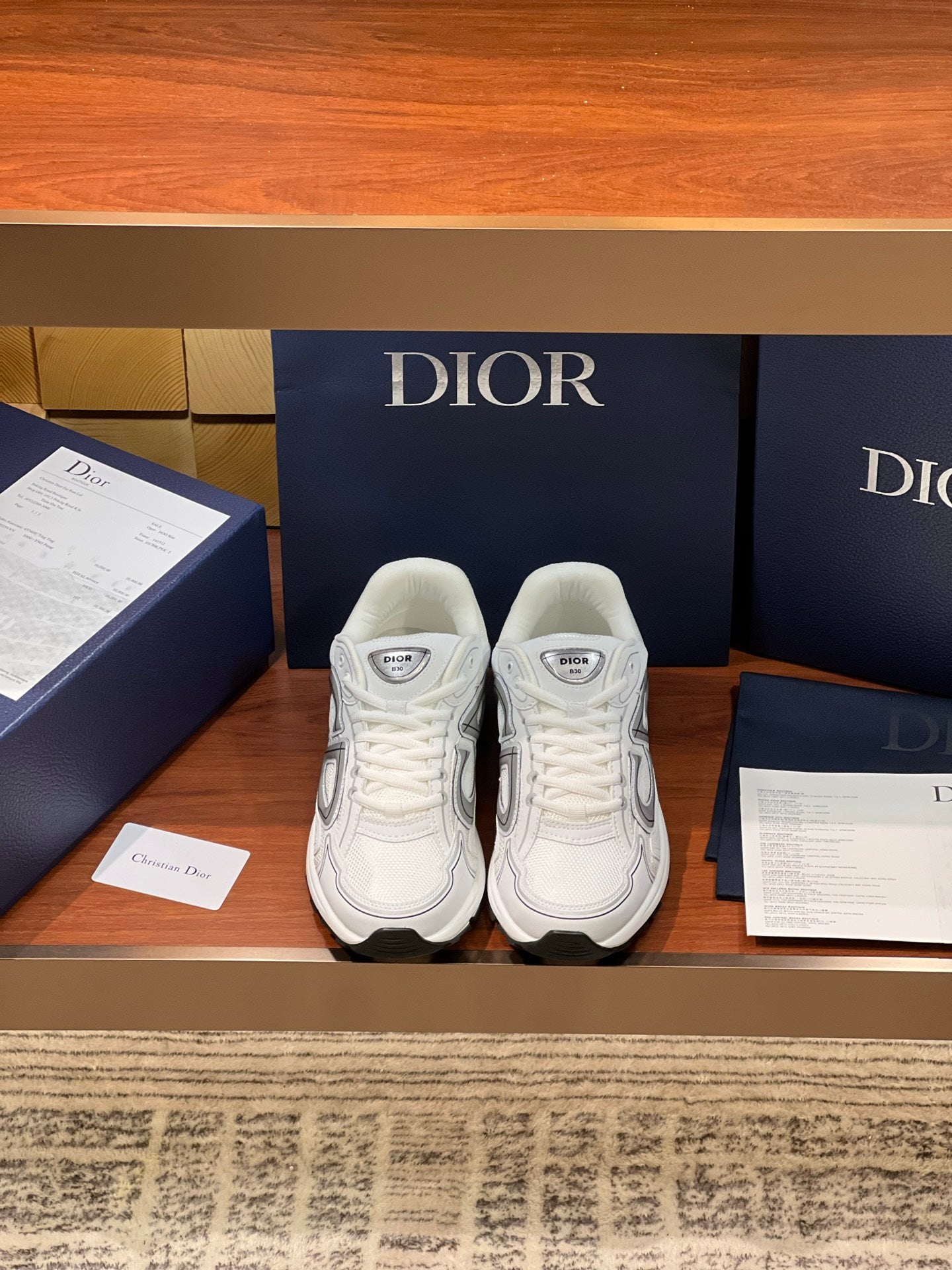 White Dior ladies sneakers with gray logo panels and lace-up front, cushioned sole