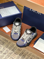 Women’s lace-up sneakers with gray upper, navy accents, white laces, black outsole.